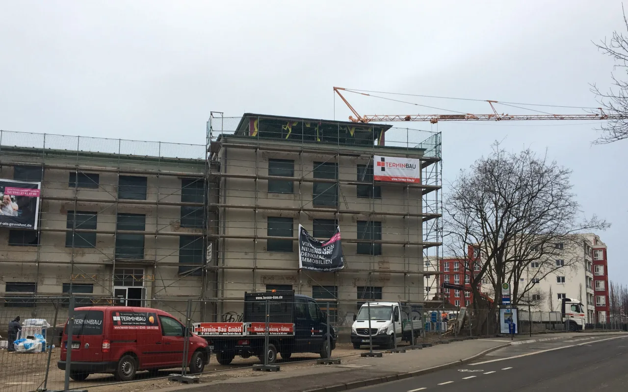 Mehrgeschossiger Neubau im Rohbau mit Gerüst, Kran und Fahrzeugen der Termin Bau GmbH