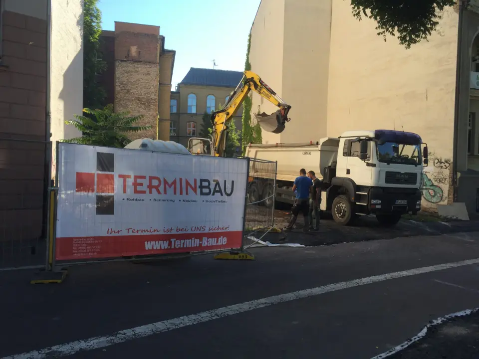 Baustelle der Termin-Bau GmbH mit Bauschild, Bagger und Lkw