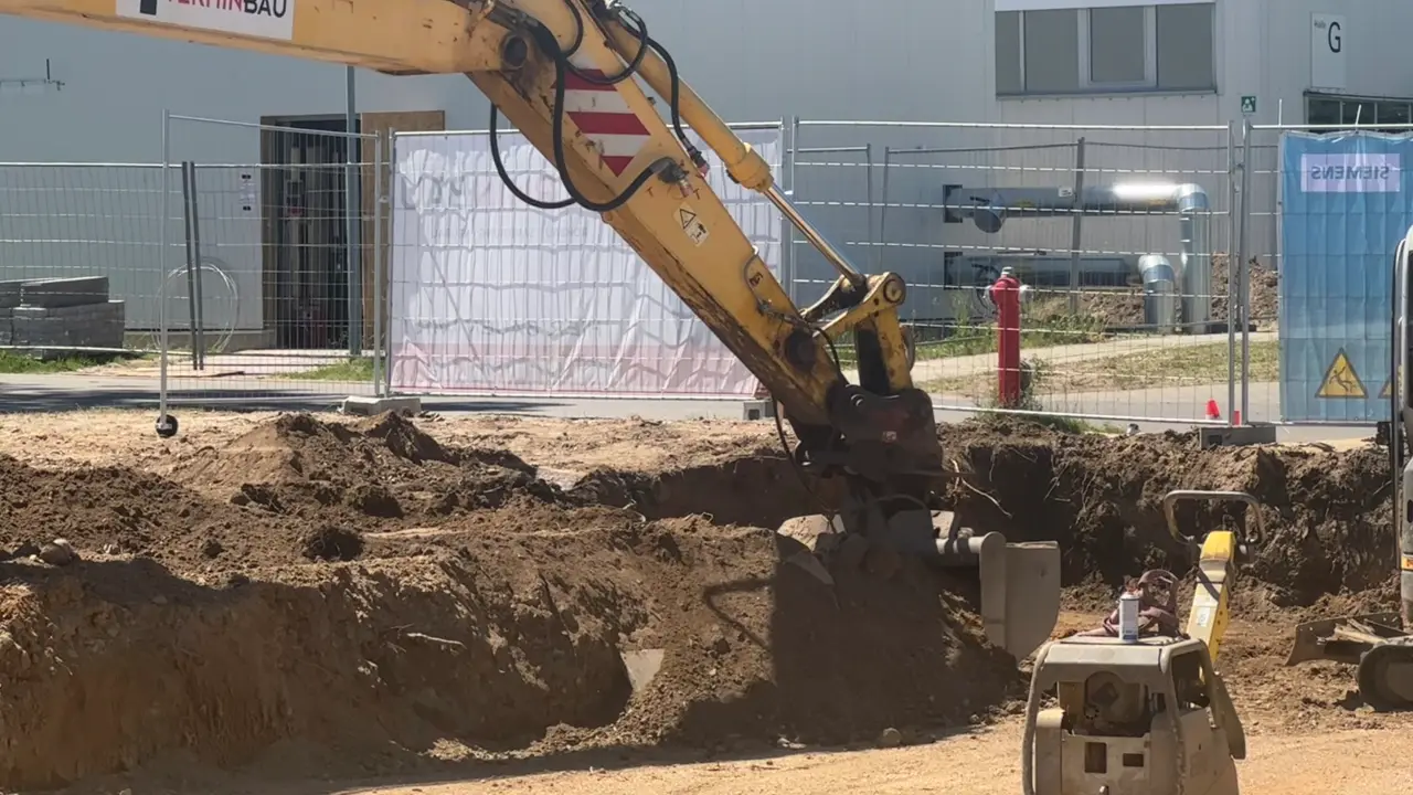 Großer gelber Bagger der Termin-Bau GmbH hebt eine Baugrube aus