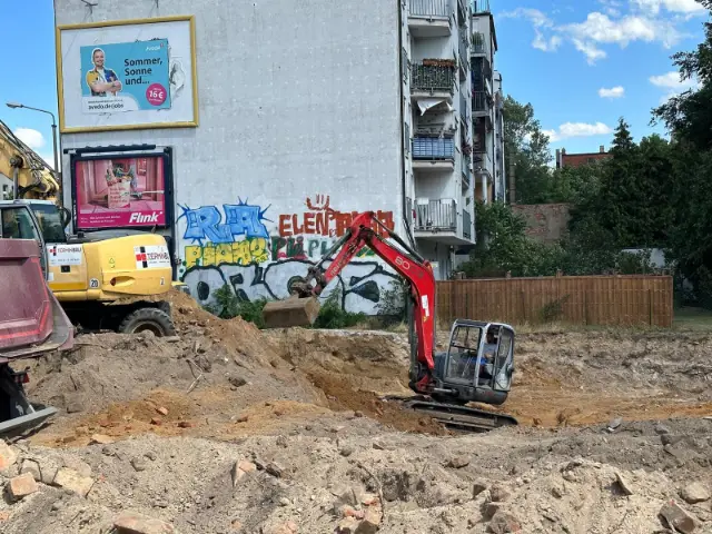 Bagger mit Verdichtungsplatte beim Verdichten des Untergrunds